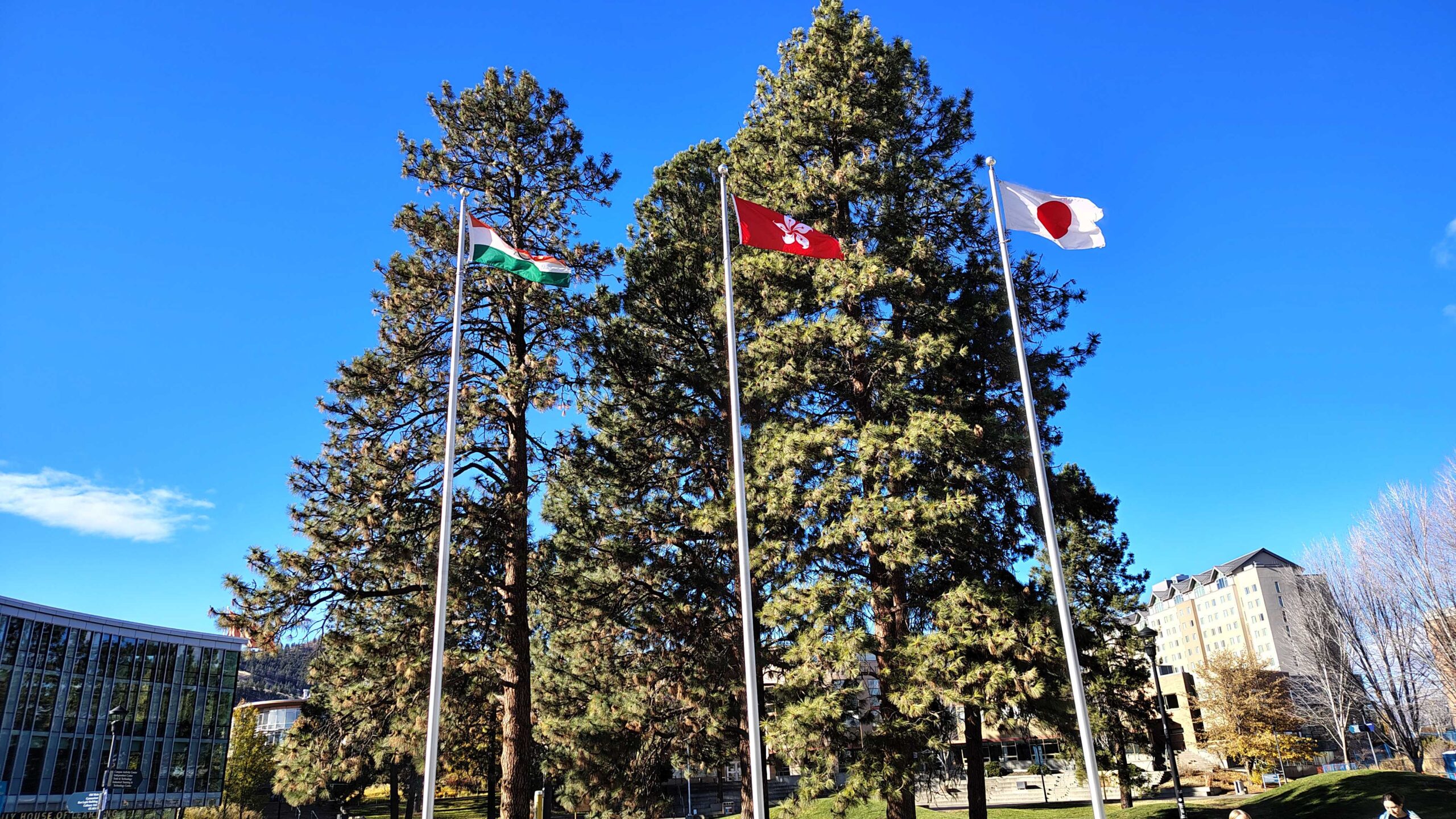 A Jade Cash ATM machine inside the CAC building at Thompson Rivers University, with an emergency evacuation route map on the wall to its left and a TRU recycling bin to its right.